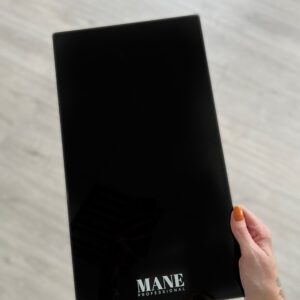 The Limited Edition XL Mane Board is a 22cm x 40cm high-gloss acrylic board designed for UK-based professional colourists. Ideal for salon use, its bevelled edge prevents foil tearing and helps speed up balayage and highlight application.